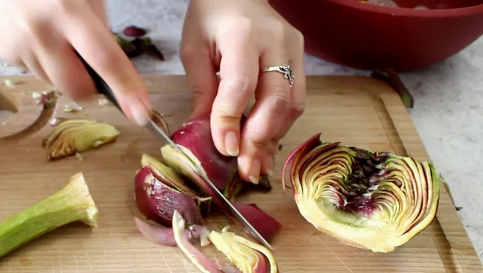 Cut the artichokes into thin slices, and also slice the stems. Soak everything in water with lemon.