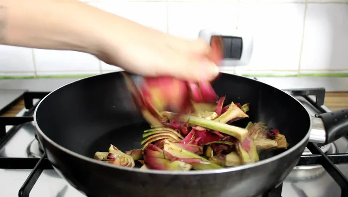Add the well-drained artichokes to the pan. Season with salt and pepper, add a ladle of broth, cover, and cook until soft (about 15 minutes).