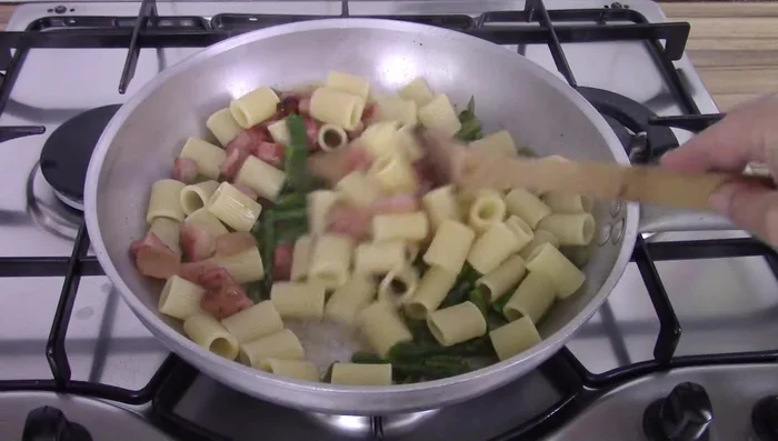 Combine cooked pasta, asparagus, bacon, and pecorino cream in the pan. Mix well.