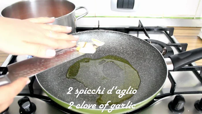 Prepare the soffritto: In a pan, add a couple of spoonfuls of oil, two chopped garlic cloves, and a little chili pepper. Fry until golden.