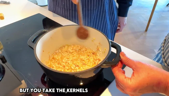 Gradually add the vegetable stock, stirring continuously and scraping the bottom of the pan to prevent sticking.