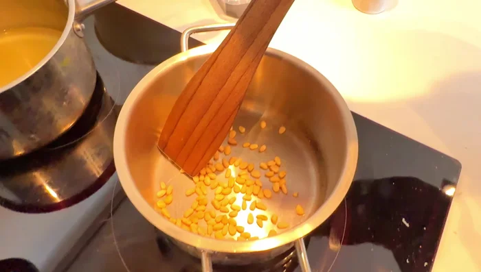 Lightly fry the pine nuts until golden brown.