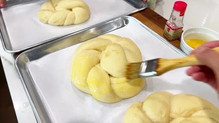 Whisk together an egg and 1 teaspoon of water. Brush each bread with the egg wash.