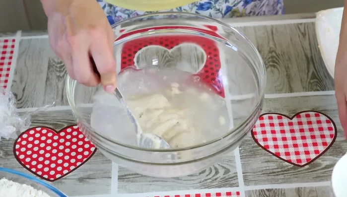 Combine ingredients: In a large bowl, add water, a pinch of salt, and gradually add sifted flour, mixing well with a spoon until a soft, fluffy dough forms. (165.64)