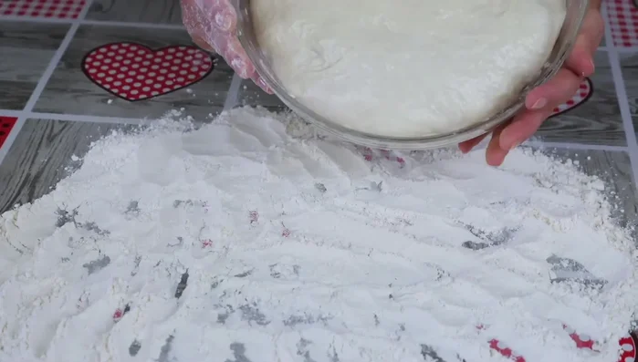 Shape ciabatta: Turn the risen dough onto a well-floured surface. Cut the dough lengthwise in half, then each half into four pieces. Gently shape each piece into a ciabatta loaf and place it on the prepared parchment strips. (648.88)