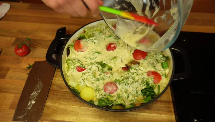 Pour the butter mixture over the vegetables, ensuring it's spread evenly. Sprinkle with extra parmesan cheese and pepper.