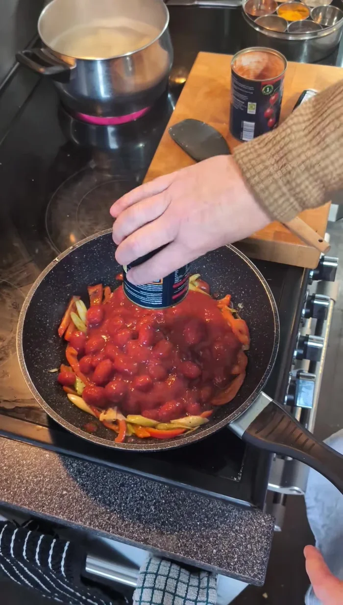 Stir in canned tomatoes, cherry tomatoes, tomato puree, and basil. Simmer for a minute.