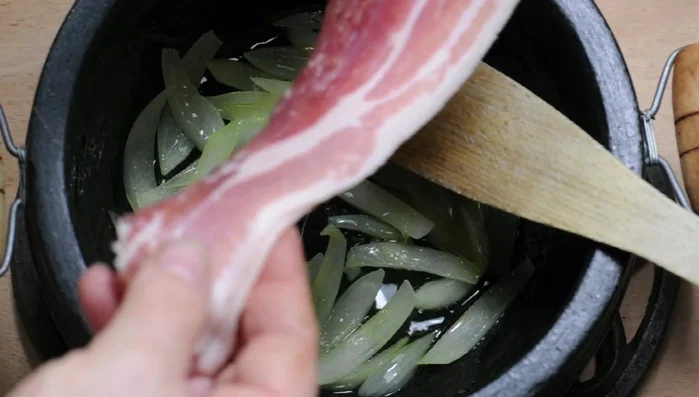 Heat olive oil in a casserole. Add chopped onion and diced bacon (optional), and stir-fry until softened.