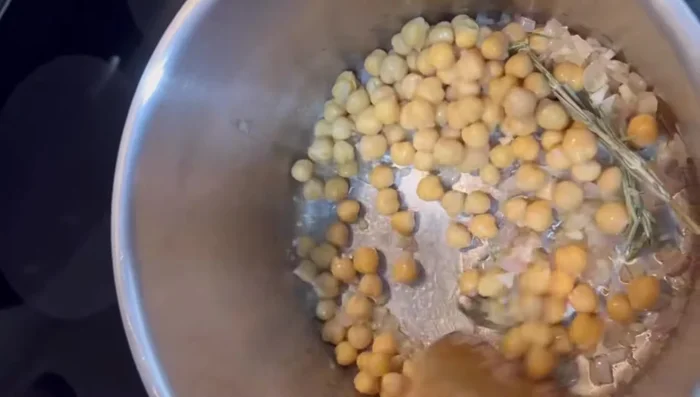 Add half of the canned chickpeas to the pot.