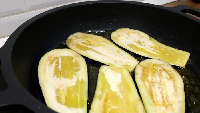 Fry the eggplant slices in a pan over medium-high heat until golden brown, flipping as needed. Alternatively, roast them in the oven for a lighter option.