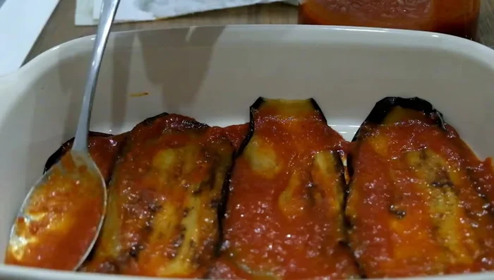 Continue layering eggplant and tomato sauce, alternating with freshly grated Parmesan cheese and chopped basil leaves, if desired. You can remove some of the eggplant skin if preferred.