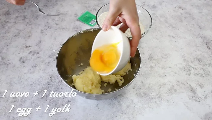Add the eggs (one whole and one yolk), a little vanilla, and a pinch of salt. Mix with a fork.