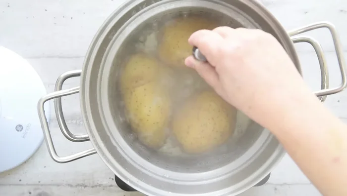 Check if potatoes are cooked through by piercing the center with a knife. Peel hot potatoes immediately if using a manual ricer.