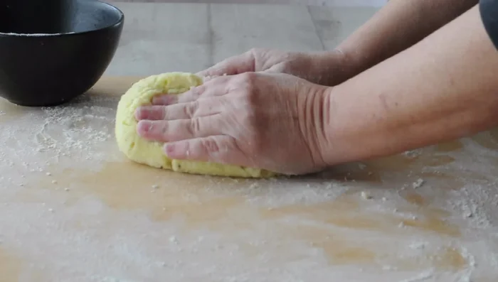 Gently incorporate flour into potatoes, folding and pressing until dough comes together.