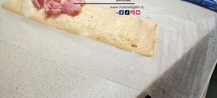 Arrange the ham roses and courgette stems on the pizza.