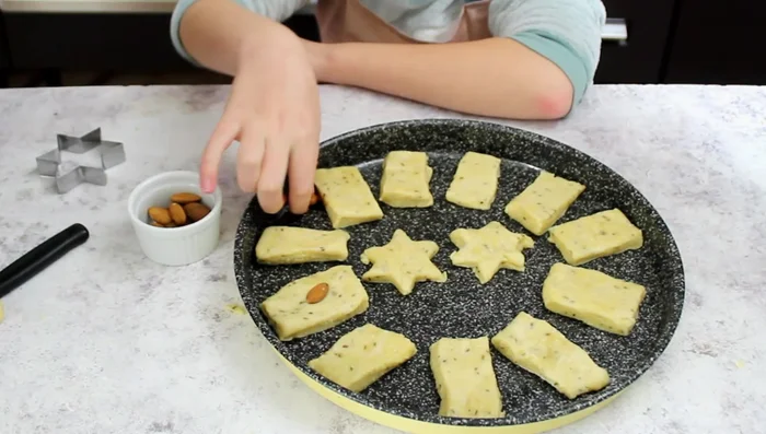 Press an almond onto each biscuit.