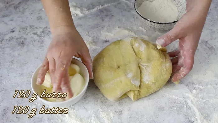 Gradually incorporate softened butter into the dough, kneading for about 10 minutes until elastic.