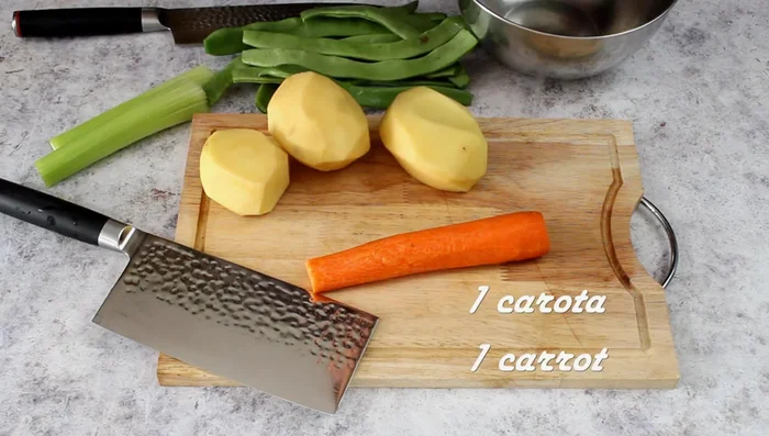 While the meat cooks, prepare the vegetables: peel and chop the carrots, potatoes, and celery. Cut the snow peas into pieces.