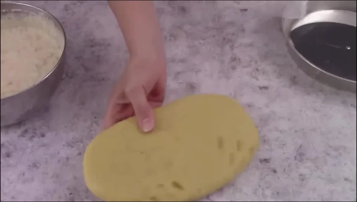 Roll out shortcrust pastry, line a pastiera mold, and fill with the ricotta mixture. Decorate with pastry strips.