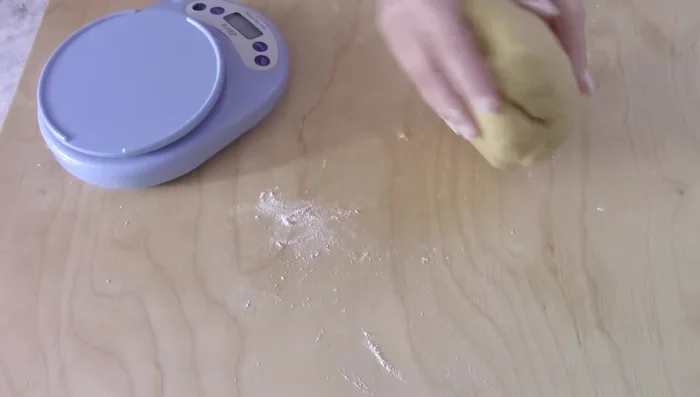 Divide dough into three parts, roll into cords, braid, and place hard-boiled eggs inside.