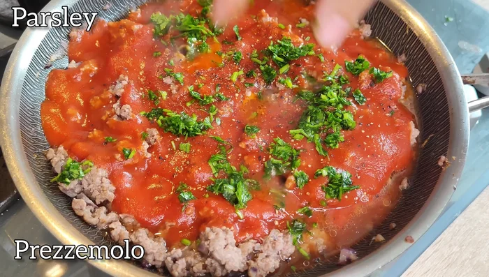 Assemble the Eggplant: Layer the eggplant slices in a baking pan, alternating with spoonfuls of the tomato sauce and fresh basil leaves.