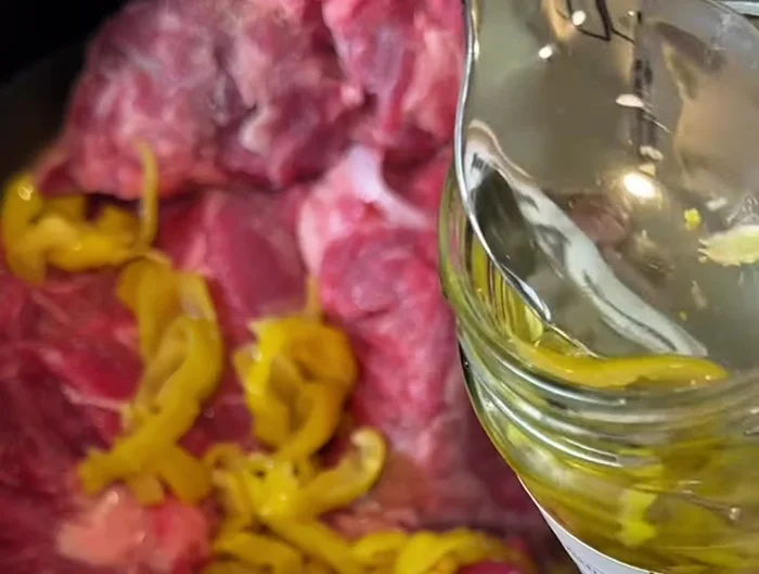 Add pepperoncini peppers and some of their brine to the slow cooker.