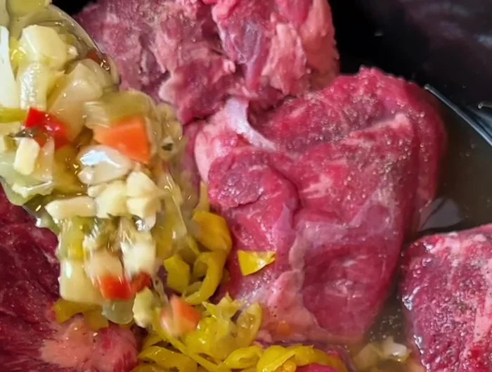 Add giardiniera (pickled vegetables) to the slow cooker.