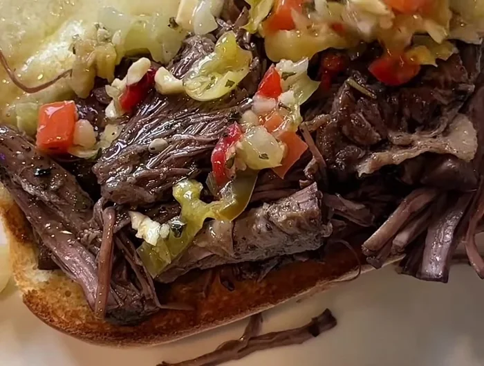 Add the shredded beef to the toasted rolls with provolone. Add extra giardiniera or pepperoncini peppers, as desired.