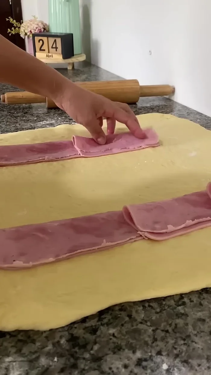 Layer ham, mozzarella, tomato, thinly sliced onion, and oregano on the dough.