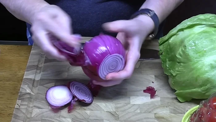Chop red onion, cherry tomatoes, and iceberg lettuce into bite-sized pieces.