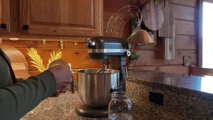 Add yeast, sugar, and warm water to the mixing bowl. Whisk together and let it sit.