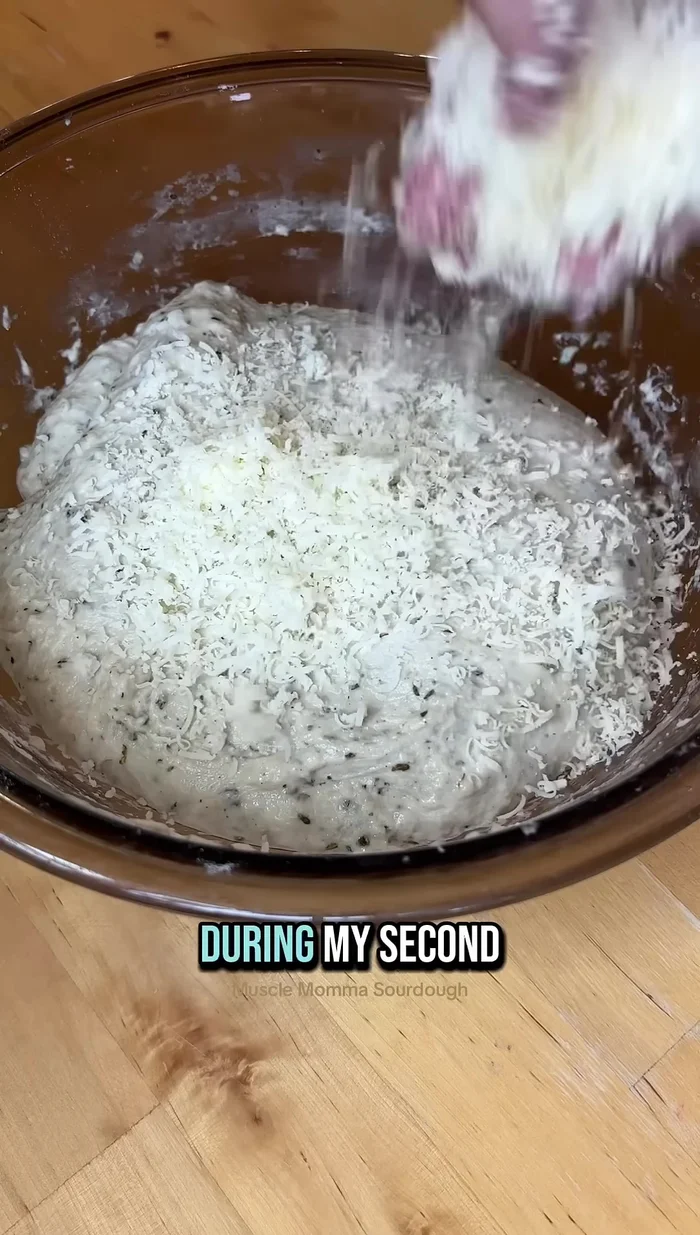 During the second set of stretch and folds, add a mixture of Parmesan and Asiago cheese.