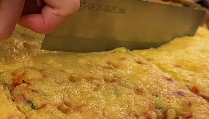 Layer lasagna noodles, ricotta mixture, and vegetable sauce.
