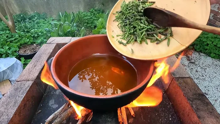In a pan, pour olive oil. Add asparagus, minced herbs, white wine, and garum.
