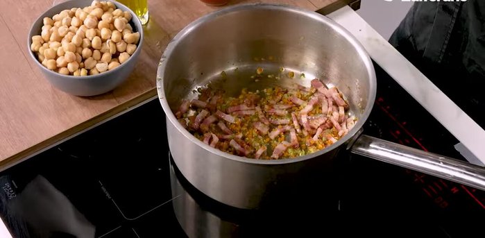 When the bacon is well browned, deglaze with some white wine. Once the alcohol has evaporated, add the pre-cooked chickpeas. Season with salt and pepper.