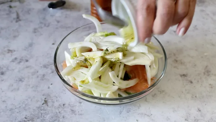 Dress the potato, salmon, and broad bean salad.