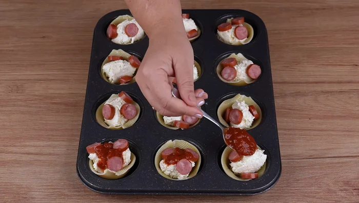 Add 1 teaspoon of tomato sauce to each shell.