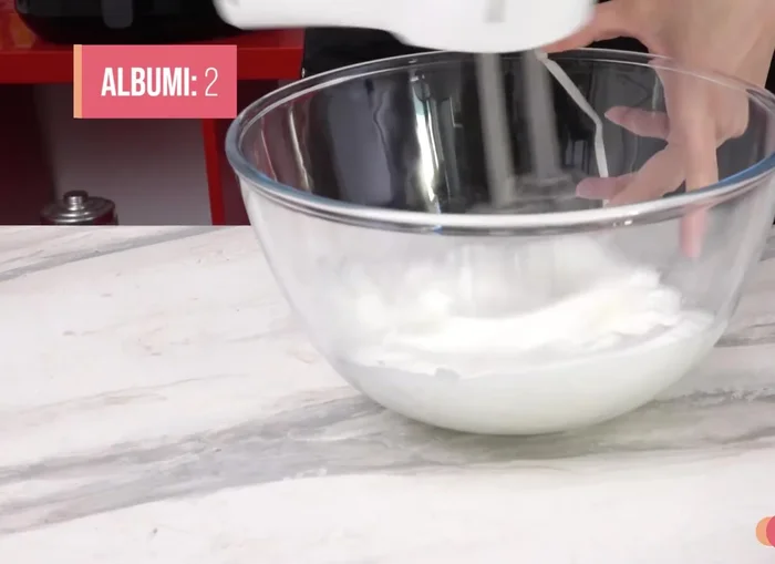 Gently fold the whipped egg whites into the batter, mixing from the bottom up to avoid deflating them.