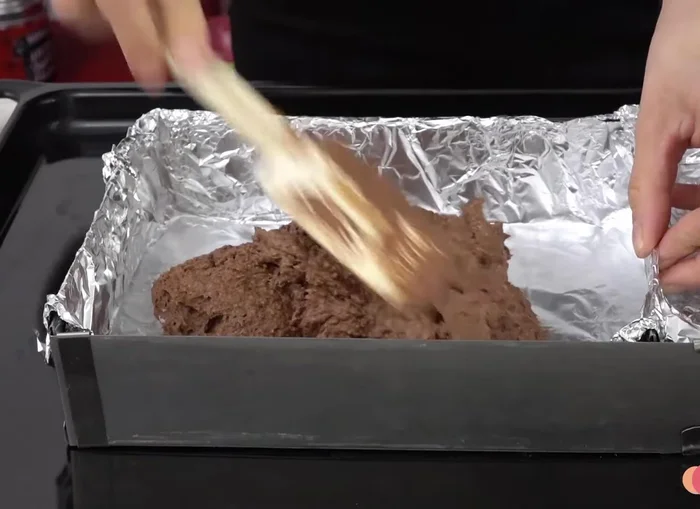 Pour the batter into the prepared mold and bake according to the recipe instructions (baking time not specified in transcript).