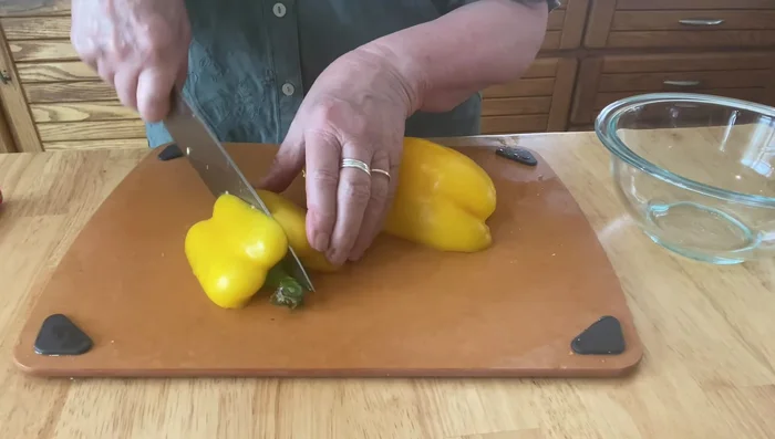 Quarter the yellow pepper, remove ribs and seeds, and cut into 1/2-1 inch slices, then into small squares.