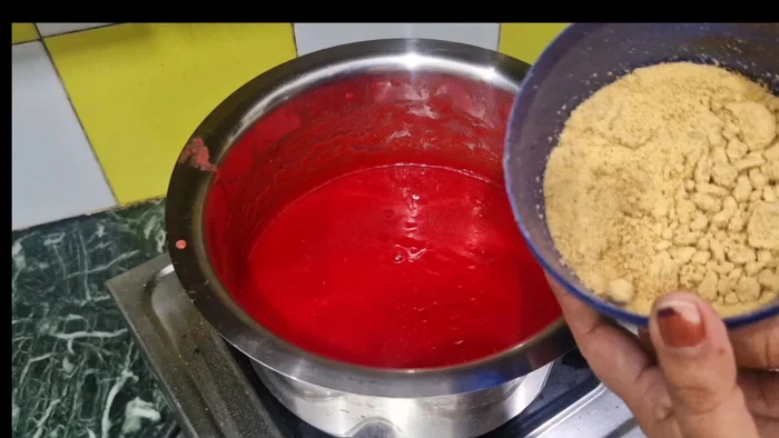 Cook the tomato pulp in a pan on medium heat for 10-15 minutes. Add 250 grams of jaggery or sugar, 1/2 cup of vinegar, 1 tablespoon of salt, 1/2 teaspoon of black salt, and 1/2 teaspoon of garam masala.