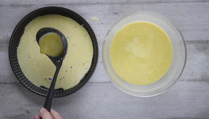 Pour the rested batter into the prepared pan. Adjust thickness as desired: thinner for crispier pancakes, thicker for a softer interior. (For a thinner pancake, pour just enough batter to coat the pan evenly; for a thicker one, use more batter – e.g., three ladles for an 11-inch pan).