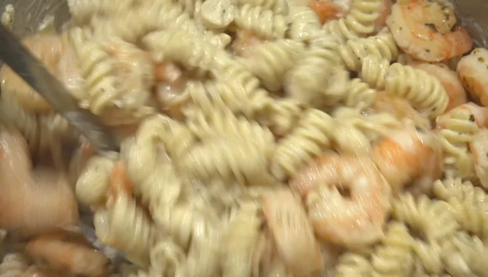 Add the cooked shrimp to the pasta and mix. (280.639)