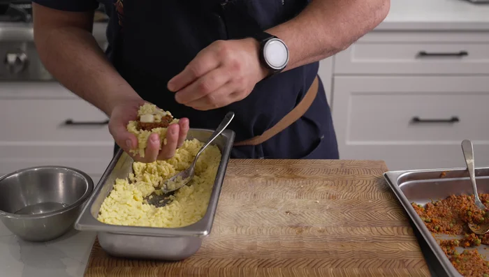 Assemble the Arancini: Wet your hands, take some chilled rice, make a divot, add ragu filling and mozzarella cheese. Cover with more rice, squeeze and shape into a ball. (Alternatively, use an arancini maker).