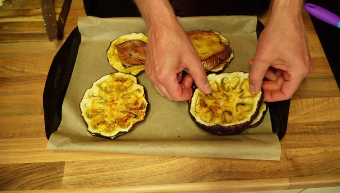 Prepare the eggplant sandwiches: Layer two eggplant slices, add the tomato-sausage mixture, grated mature cheddar, and parmesan cheese. Repeat layers.