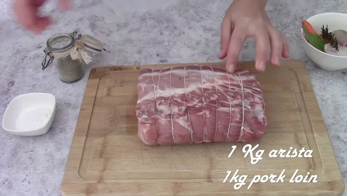 Massage the pork loin with salt and pepper on all sides. Place a sprig of rosemary under the net.