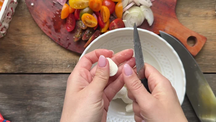 Cut cherry tomatoes and mozzarella balls into bite-sized pieces.