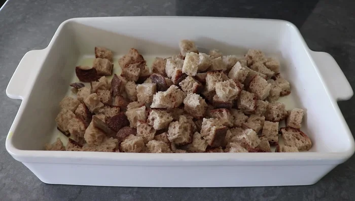 Grease a casserole dish. Layer bread cubes, then 60% of the sausage mixture, then 60% of the spinach, and half of the cheese.