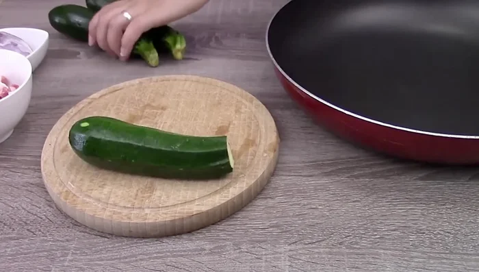 Prepare courgettes: Remove tips, halve, and cut into cubes. [Music]