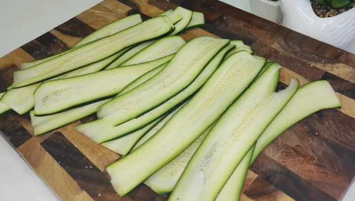 Season the zucchini with salt, pepper, olive oil, garlic and herbs (if using). (Inferred)